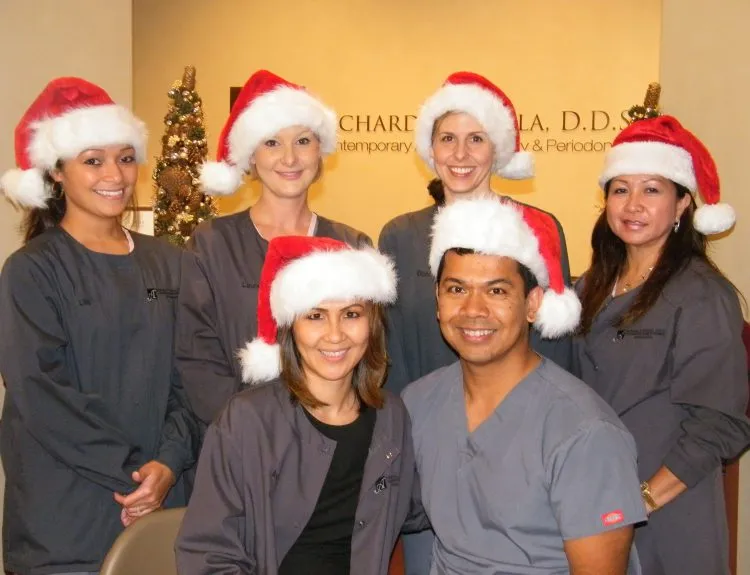 Photo of Dr. Aguila and team in Santa hats at Christmas party